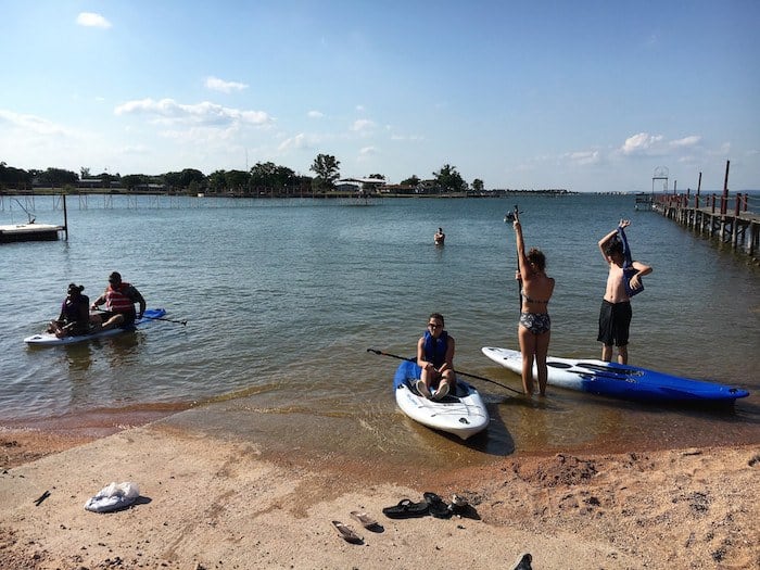 Image of guests using paddle boards at our private lake beach front. Cedar Lodge Texas has seasonal rates, but check out our specials offers page to save on your next vacation. We have the best family friendly lake cabins in Texas