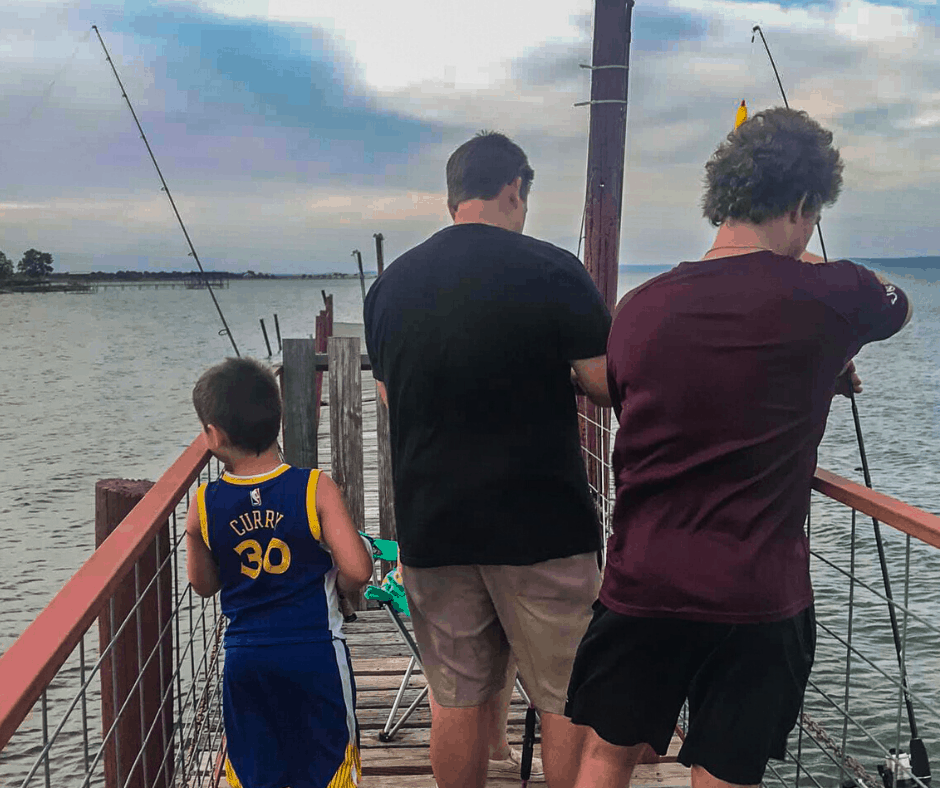 Image of a Dad and his and son's fishing out on our 50-foot fishing pier. Reserved exclusively for guests of Cedar Lodge Texas!
