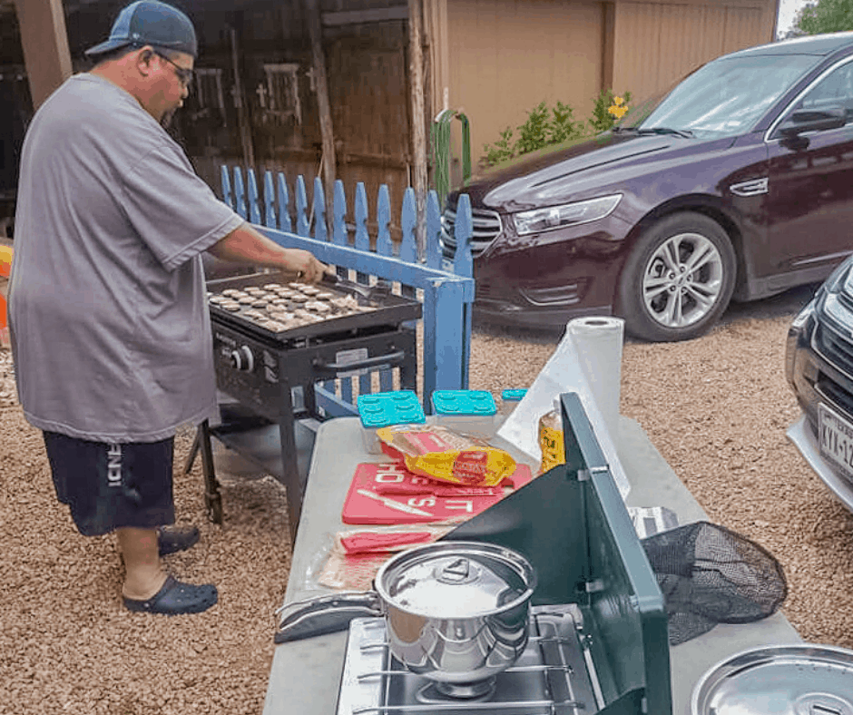 Image of dad grilling outside of his Texas cabin rental at Cedar Lodge Texas.