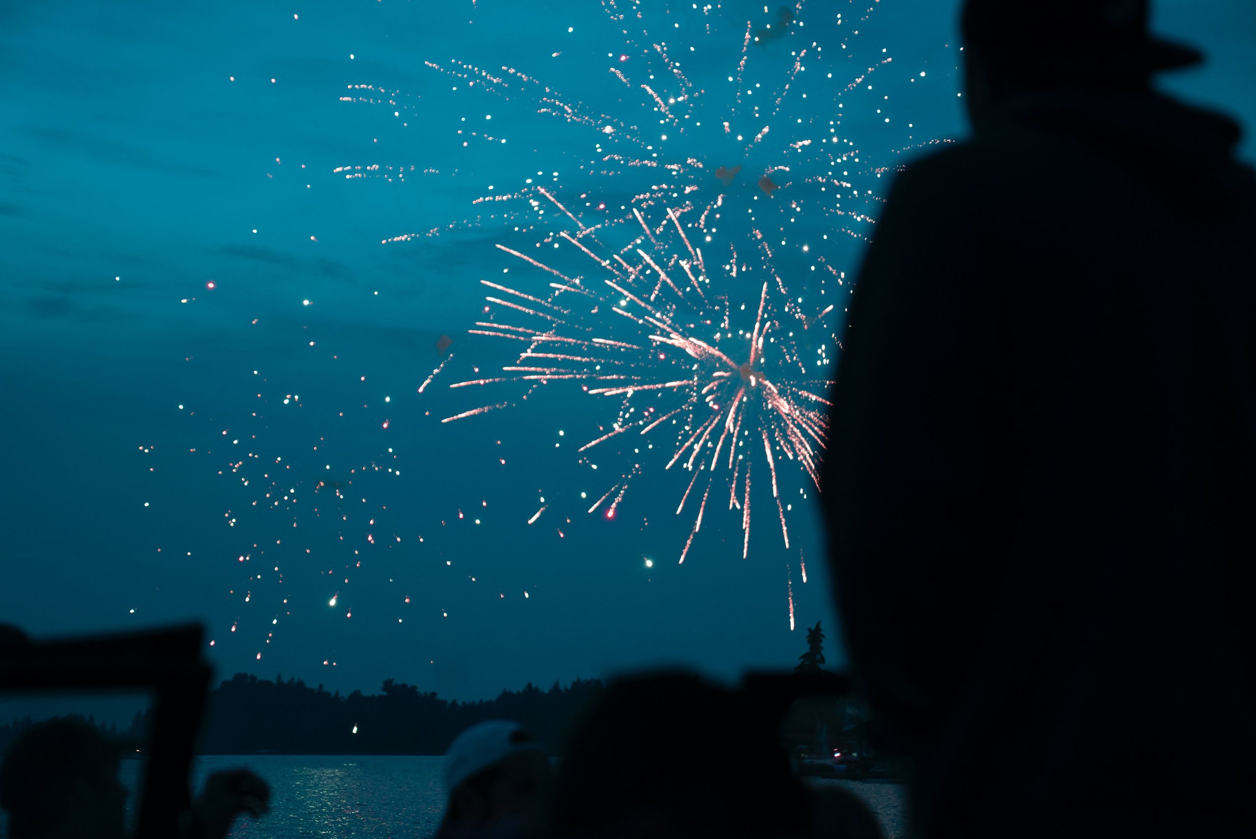 Image of guest watching fireworks over the water. You can celebrate New Years' during safely at our Texas lake cabins. 