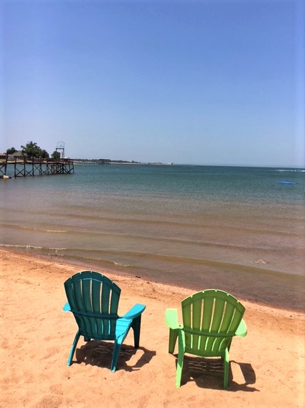 Image of empty beach chairs on our private sandy lake beachfront. Our beach, boat rentals, and amenities are reserved exclusively for Cedar Lodge guests!